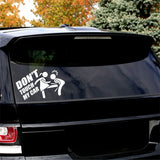 Sticker humour blanc « Don't Touch My Car » collé sur la vitre arrière d'une voiture noire